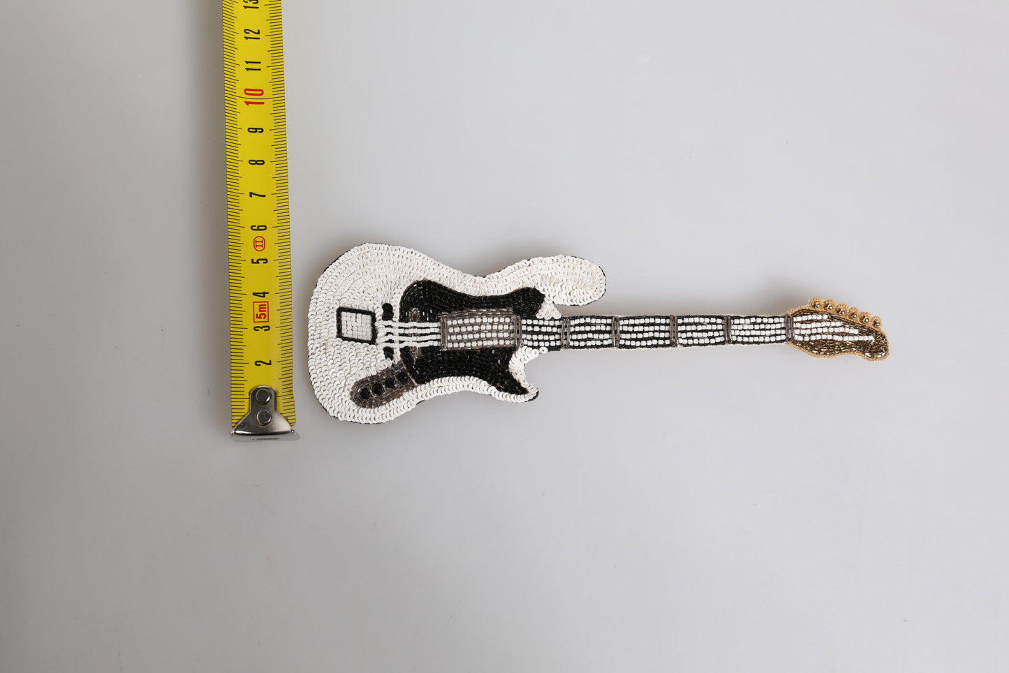 Broche en épingle à guitare Dolce & Gabbana en laiton doré avec perles et logo